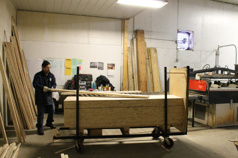 image of worker pulling lumber off a cart