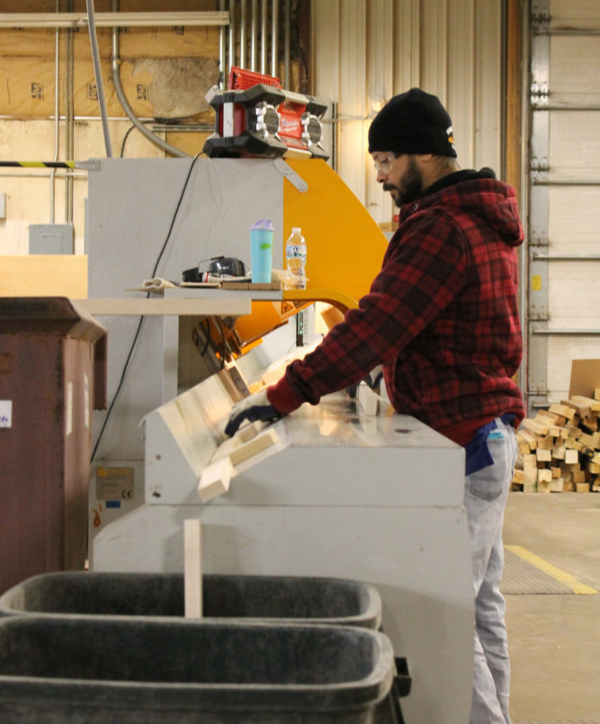 image of a man putting wood through a machine